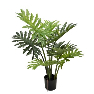 Sztuczna roślina z dużymi, zielonymi liśćmi w czarnej doniczce.