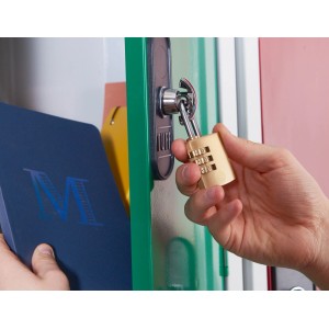 Mosiężny zamek szyfrowy przymocowany do zielonej szafki.