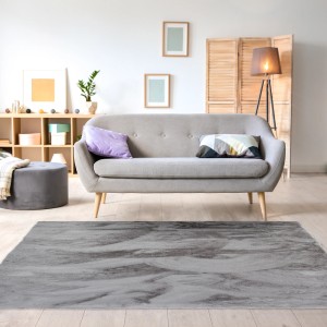 Szary dywan z długim włosiem t.b.t. w salonie z sofą. Puszysty dywan shaggy.