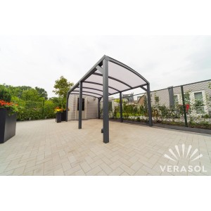 Nowoczesna szara wiata garażowa t.b.t. z przezroczystym dachem na zewnątrz.