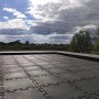 Ułożone szare płytki placu zabaw t.b.t. z połączeniem puzzli na tarasie na dachu.