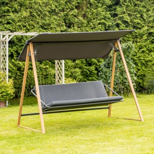 Szara huśtawka ogrodowa z daszkiem i drewnianą ramą na trawniku.