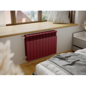 Bordowy grzejnik t.b.t. pod parapetem w sypialni.