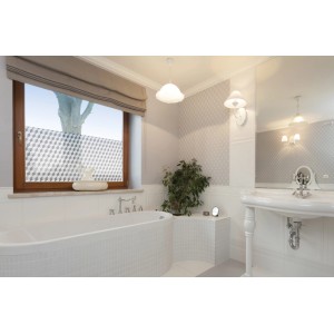 Łazienka z oknem oklejonym folią samoprzylepną we wzór kostek.