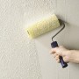 Wałek strukturalny LUX 110 mm w użyciu na ścianie z farbą strukturalną.