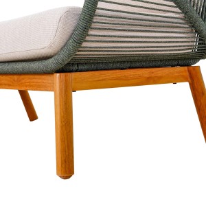 Detal zestawu mebli ogrodowych: drewniane nogi, zielona plecionka i beżowa poduszka.