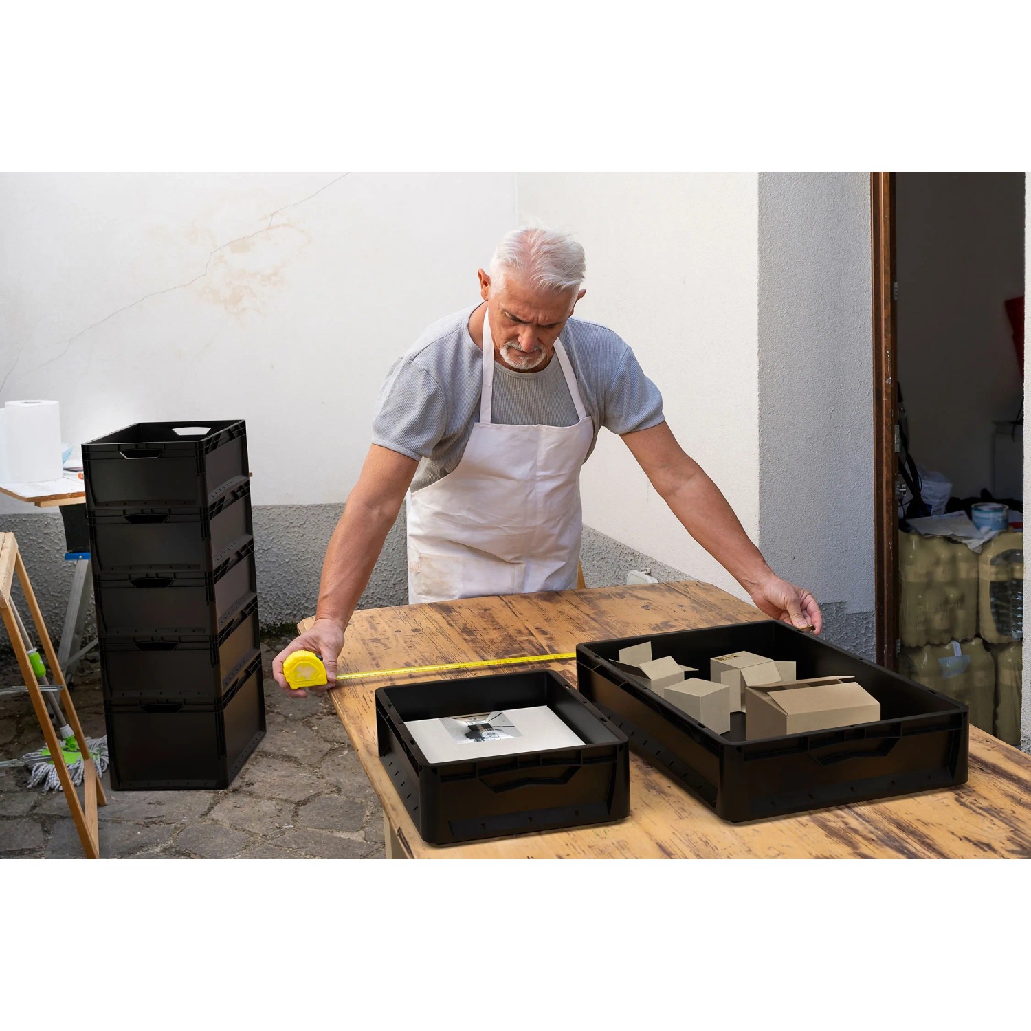 Czarny Eurobox-System Box pełna ściana 40x30x22cm z mężczyzną i miarką.
