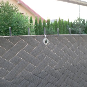 Szara mata ogrodzeniowa w jodełkę z oczkami do mocowania.