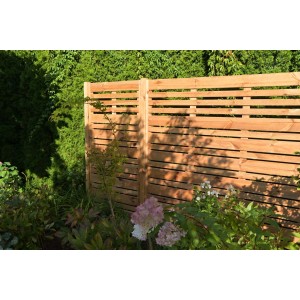 Drewniany płot t.b.t. w ogrodzie, naturalny wygląd drewna dla prywatności i aranżacji ogrodu.