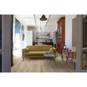 Salon z jasną podłogą winylową t.b.t. w wyglądzie drewna, sofą i wyposażeniem.